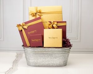 A metal tub filled with gift boxes and ribbon.