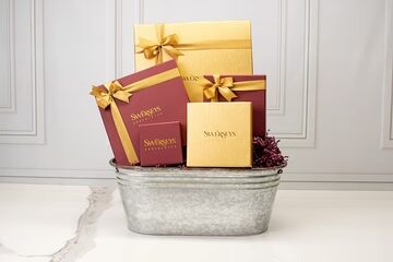 A metal tub filled with gift boxes and ribbon.