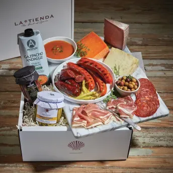 A box of food with meat, cheese and other foods.