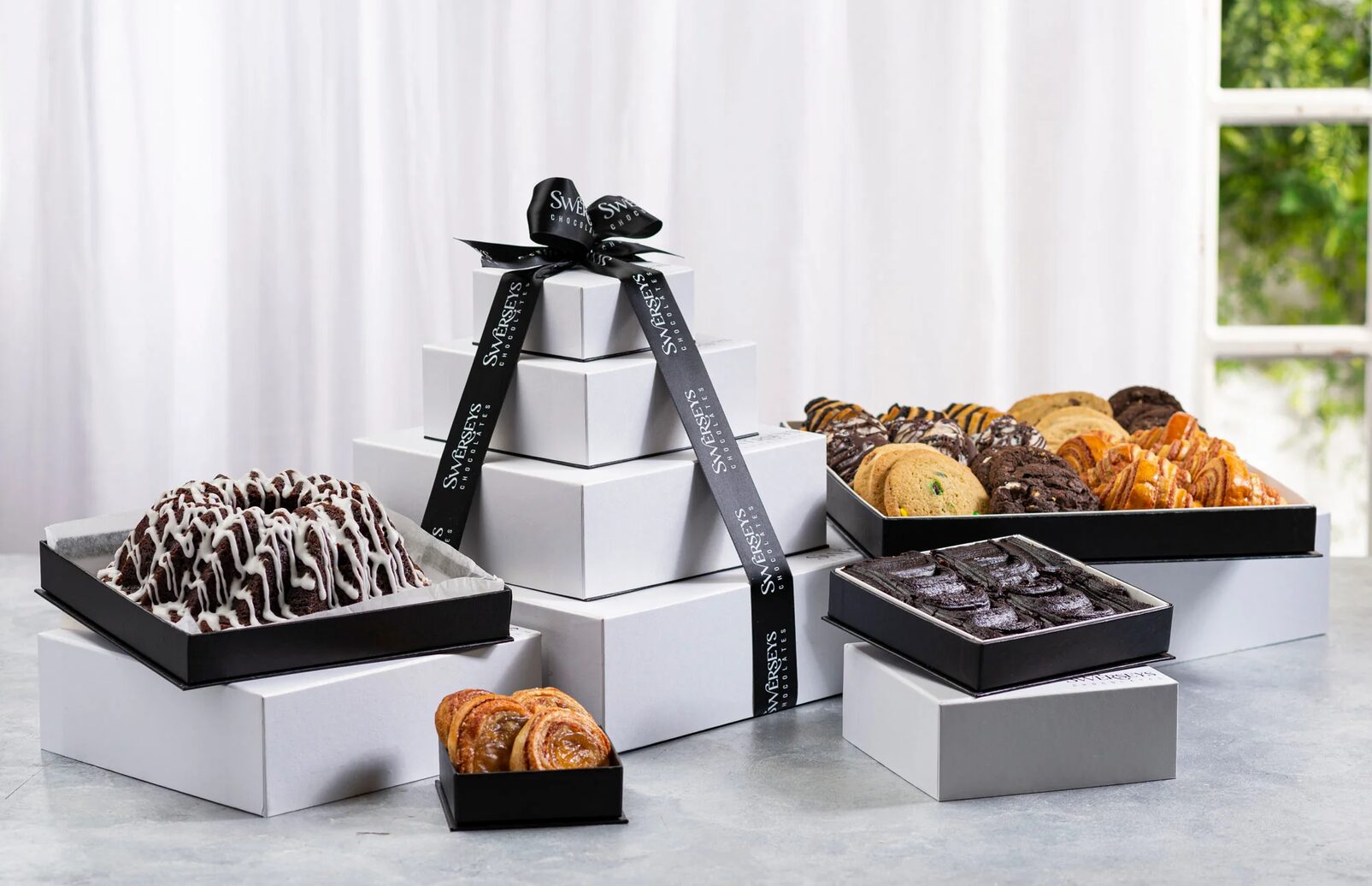 A table topped with boxes of different types of pastries.