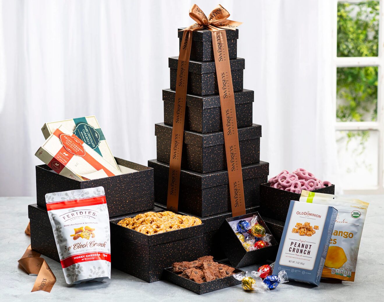 A tower of chocolate covered snacks on top of a table.