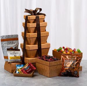 A tower of chocolate covered fruit and snacks.