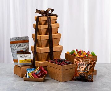 A tower of chocolate covered fruit and snacks.