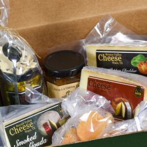 A box of cheese and other items in plastic wrap.